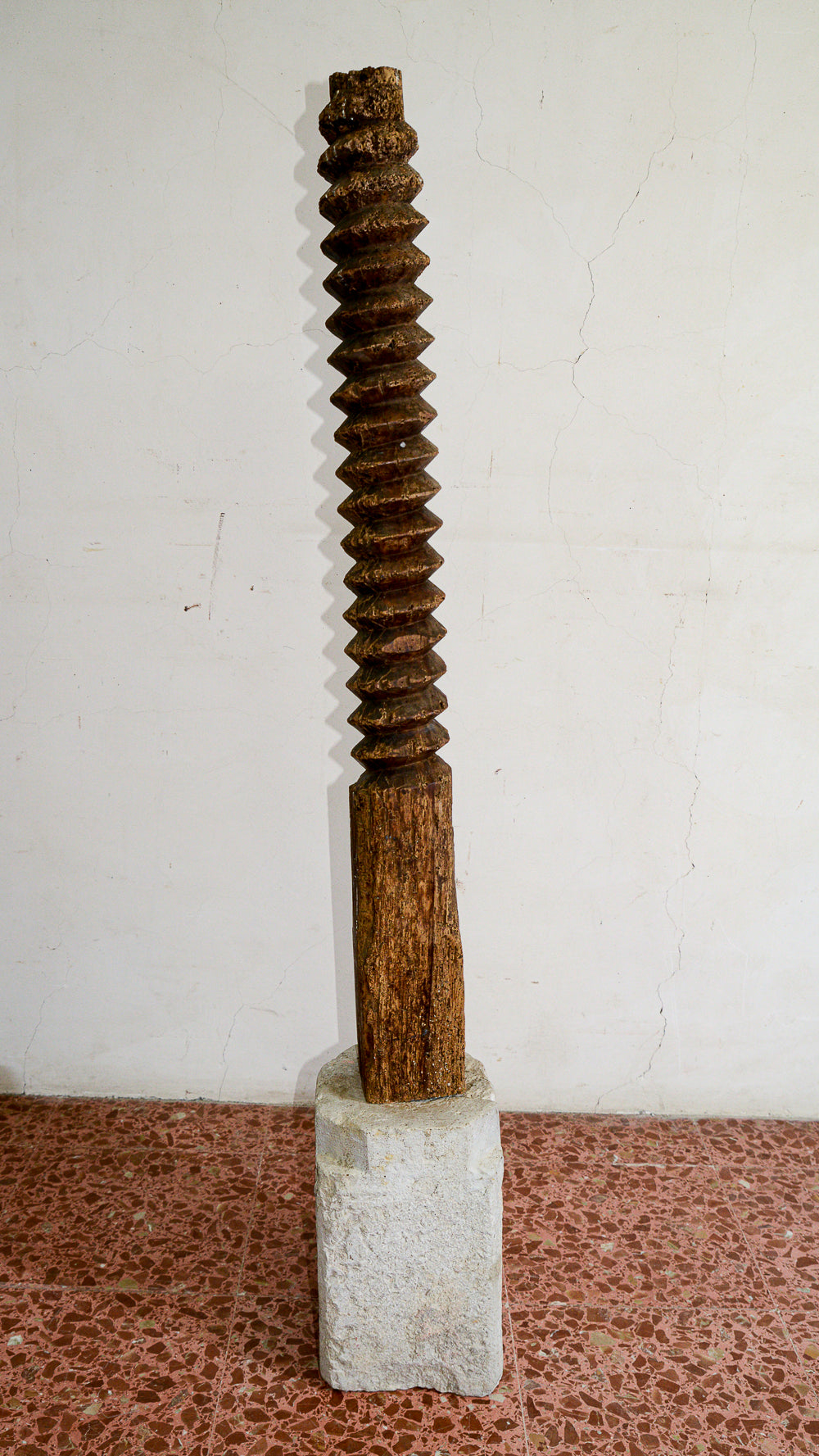 Struttura vite tornita in legno di torchio  con evidenti segni del tempo con base in pietra sagomata