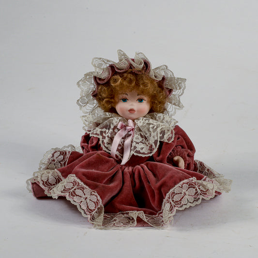 Bambola in porcellana vestito in velluto rosa antico