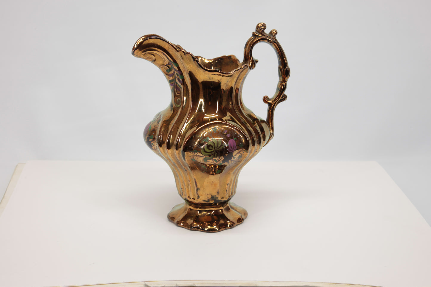 Brocca Liberty in ceramica con finitura oro a lustro. Questo oggetto da collezione, integro e ben conservato, misura 19 x 17 cm con un'altezza di 21,5 cm.