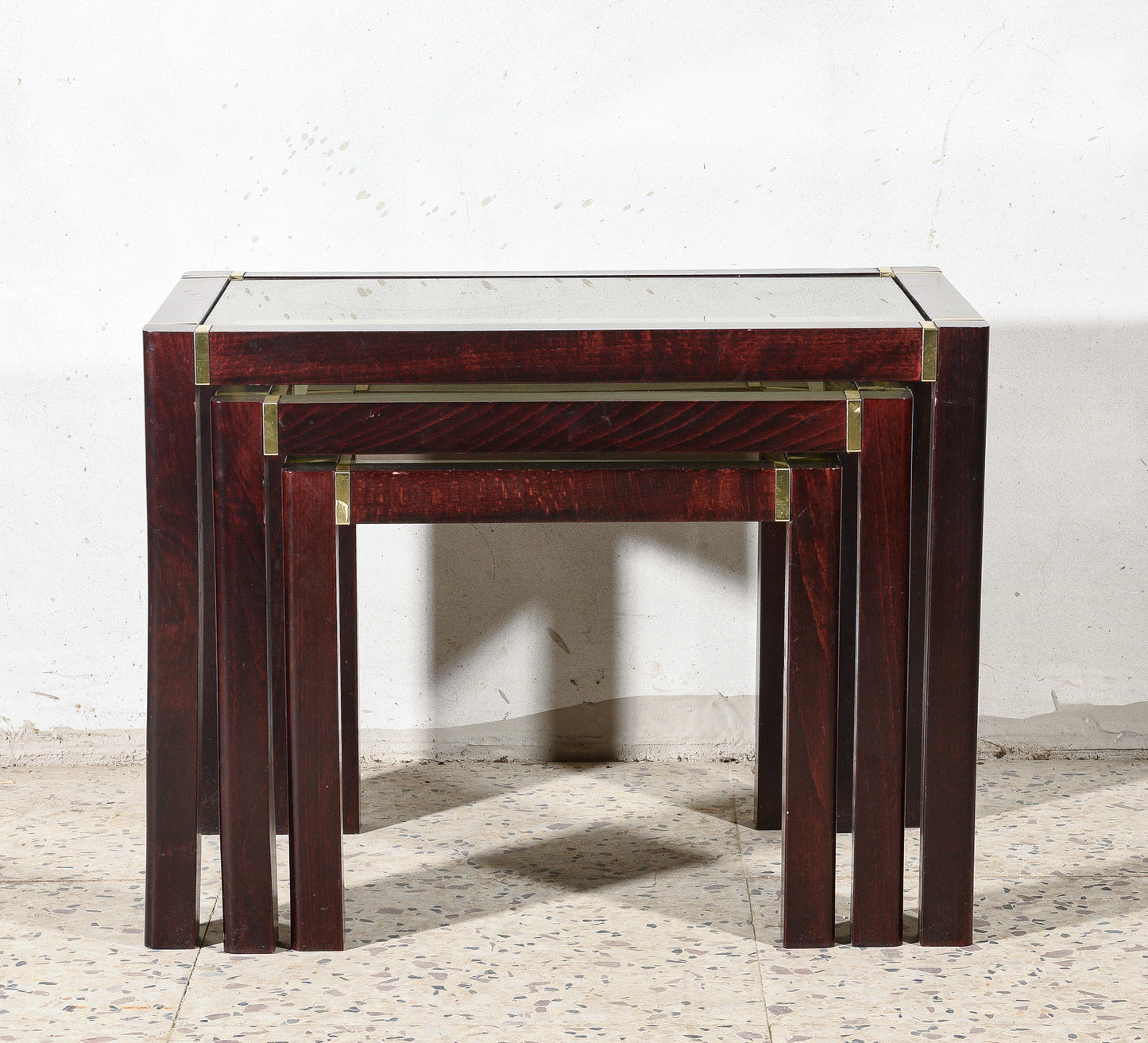 Trittico di tre tavolini impellicciati con piano in vetro e rifiniture in ottone Italia 1980