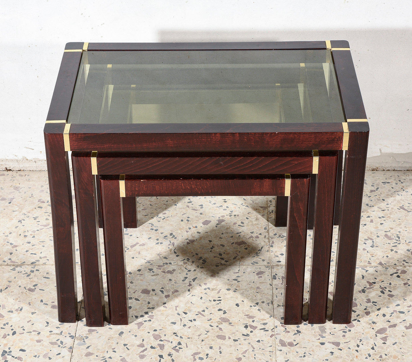 Trittico di tre tavolini impellicciati con piano in vetro e rifiniture in ottone Italia 1980