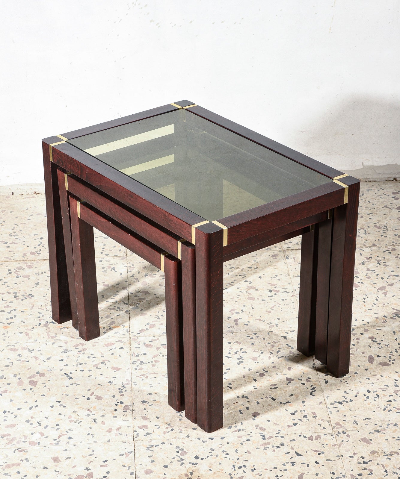 Trittico di tre tavolini impellicciati con piano in vetro e rifiniture in ottone Italia 1980