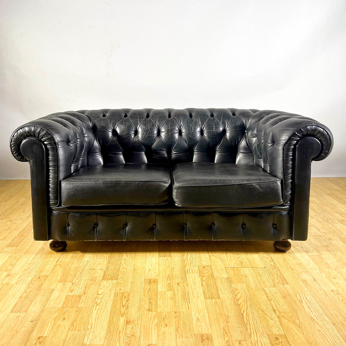 Divano Chesterfield club in pelle nera e piedi in legno anni 60